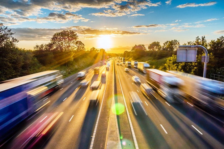 A wide angle shot of traffic moving in a blur against the sunset