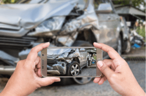 Hand of woman holding smartphone and take photo of car accident