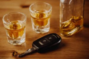 Close up of car keys and an alcohol on the table