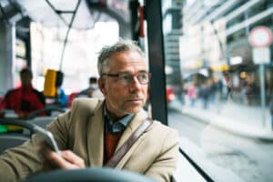 Passenger sitting near a window on a public bus, in need of bus injury liability information