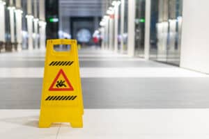 Wet floor sign in the middle of a public building to indicate the possibility of slipping and falling