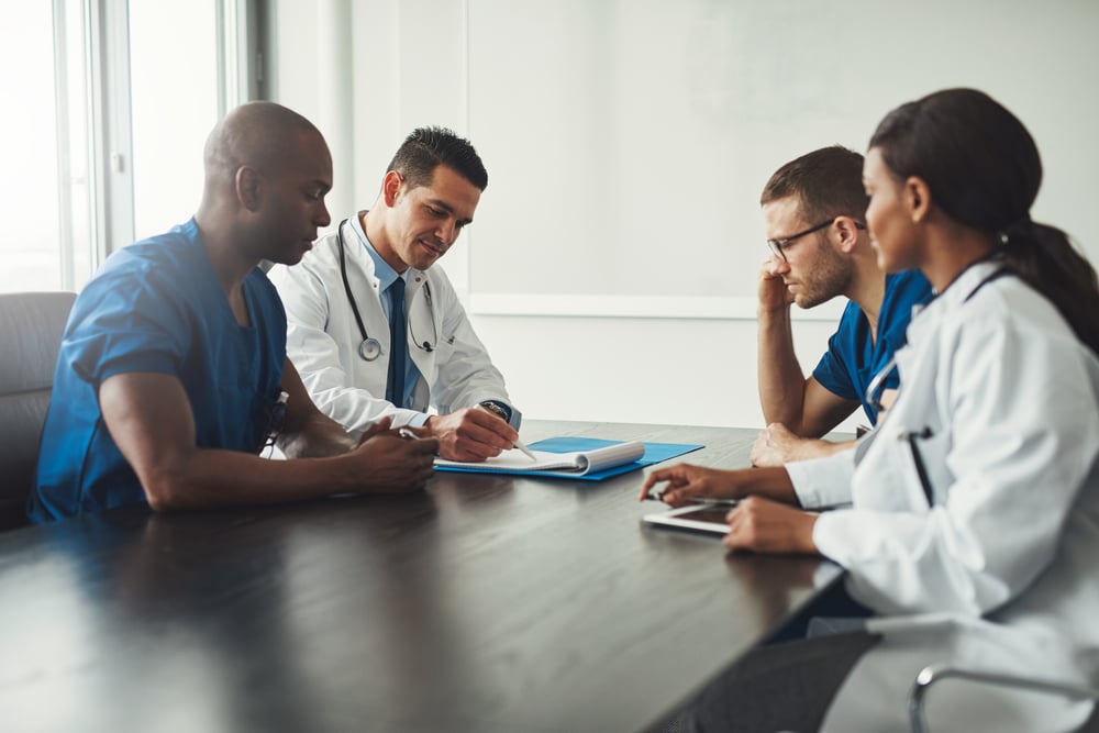 Group of people sitting at a conference table and working on an injury insurance claim. Group of people sitting at a conference table and working on an injury insurance claim.